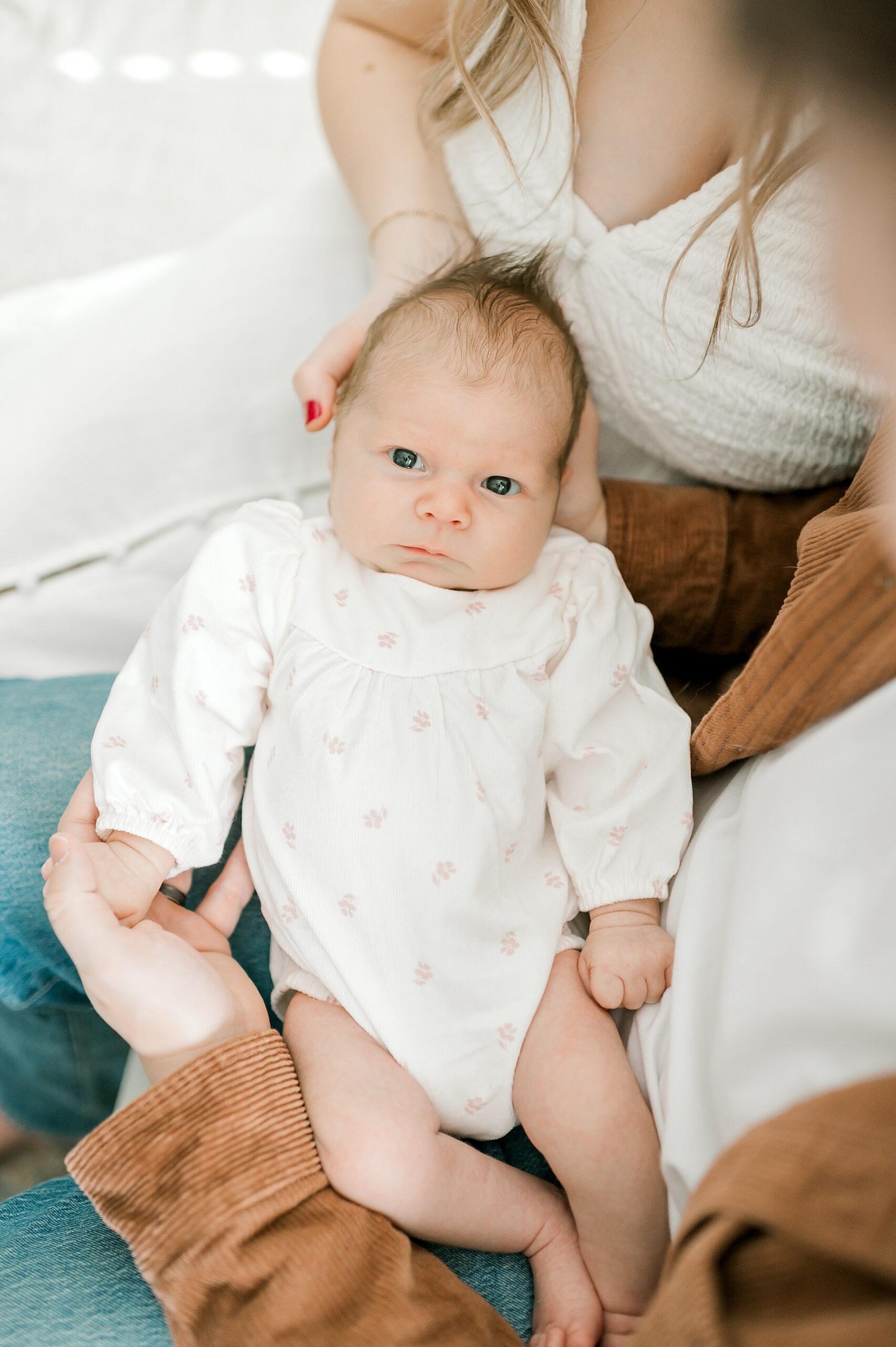 newborn girl in parents arms | Tips to Prepare For An In-Home Newborn Session