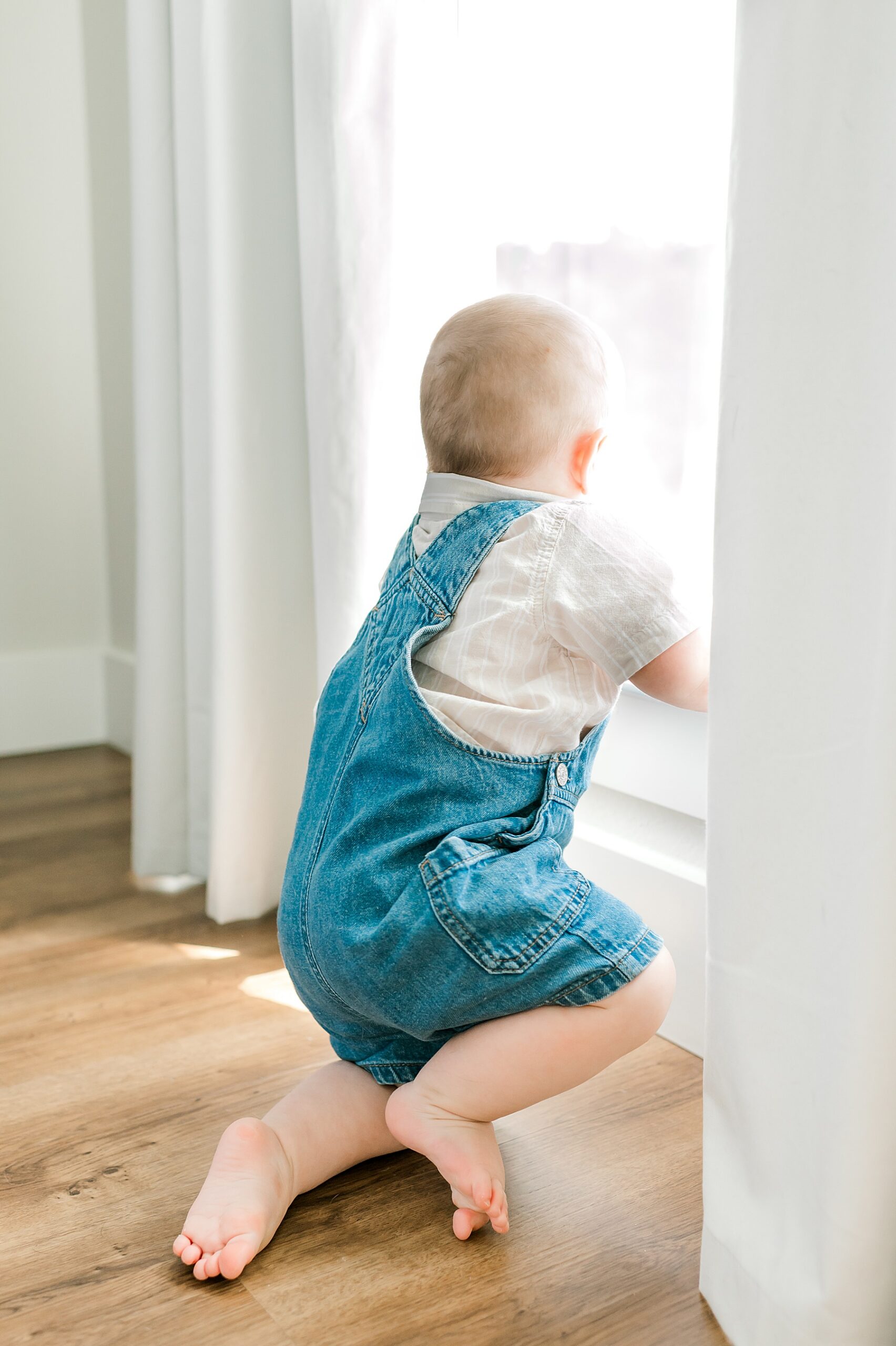 one year old boy pulls himself up to stand